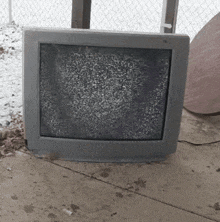 a gray television is sitting on a concrete floor