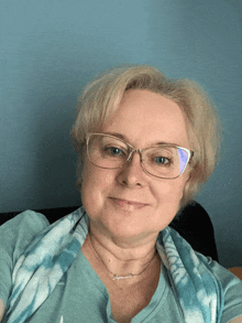a woman wearing glasses and a necklace that says ' agatha ' on it