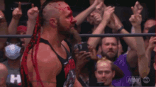 a man with blood on his face is wearing a tank top that says monster