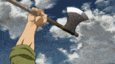 a hand is holding a large axe in the air