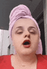 a woman with a towel wrapped around her head is yawning