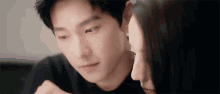 a man and a woman are touching each other 's faces and looking at each other .