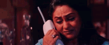 the woman is crying while talking on the phone .