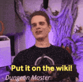 a man is holding up a sign that says put it on the wiki