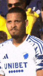 a man in a blue and white unibet shirt