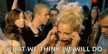 a woman is talking on a cell phone while dancing in a crowd of people .