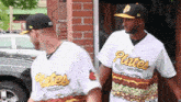 two baseball players wearing plates jerseys are walking down the street
