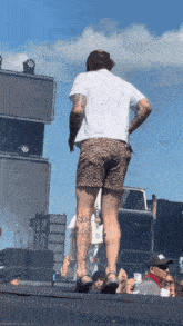 a man in leopard print shorts stands on stage