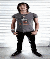 a young man wearing a mickey mouse t-shirt is standing with his hands in his pockets