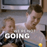 a man is holding a little boy and saying " we 're not going "