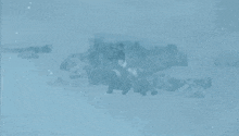 a person is standing in the snow near a rock