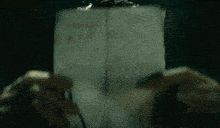a close up of a person holding a piece of paper with the word thank you written on it