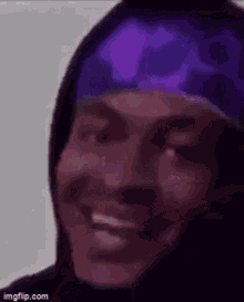 a close up of a person wearing a purple hat and a hoodie .