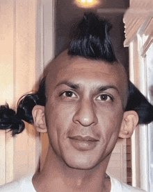 a man with a mohawk and a ponytail on his head