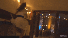 a girl in a white dress is dancing in a room with netflix written on the bottom right