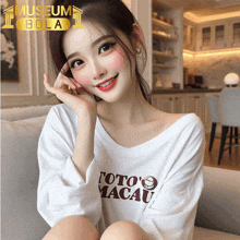 a woman wearing a white shirt that says " foto 's macau "