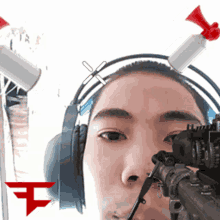 a man wearing headphones and a sniper rifle with a red t on the bottom