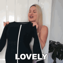 a woman is holding a black shirt and the word lovely is written on the bottom