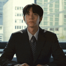 a man in a suit and tie is looking at the camera