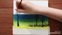a person is painting a landscape with the words made in animotica below them