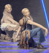 a man and a woman are dancing on a stage with a blue light behind them