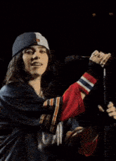 a woman is singing into a microphone while wearing a baseball cap