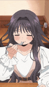 a girl with purple hair is sitting at a table eating with a fork