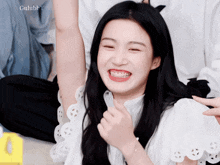 a girl with a white shirt on is smiling and giving the thumbs up