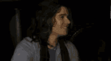 a blurry picture of a man with long hair laughing and making a funny face .