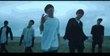 a group of young men are standing next to each other in a field .