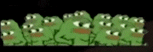 a bunch of green frogs are standing next to each other in a row .