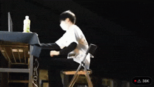 a man wearing a face mask is sitting in a chair .