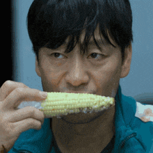 a man is eating corn on the cob with his mouth open