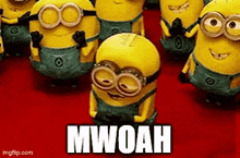 a group of minions are standing next to each other on a red carpet and one of them says mwoah .