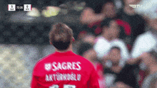 a soccer player wearing a red shirt that says sagres on it