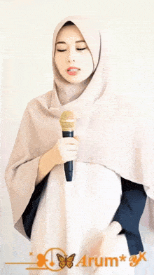 a woman in a hijab is holding a microphone with the words izin satu lagu ya