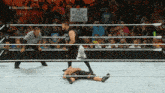 a man in a wrestling ring holds a sign that says straight out of a graveyard