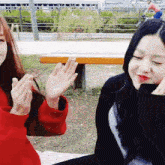 a woman in a red sweater sits next to another woman