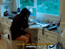 a woman sits at a desk talking on a cell phone and says i 'll be right back