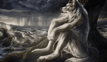 a white wolf is sitting under a tree on a rock near the ocean .