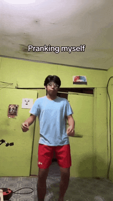 a man in a blue shirt and red shorts is pranking myself in a room