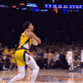 a basketball player in a yellow jersey with the number 2 on the back