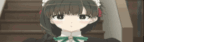 a girl in a maid costume is standing on a set of stairs looking at the camera .