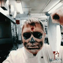 a man with a skull painted on his face is holding a knife over his head