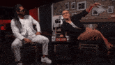 two men are sitting at a table with a sign that says hey on it