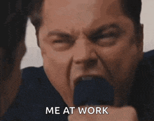 a man in a suit and tie is screaming with his mouth open and the words `` me at work '' written on his face .