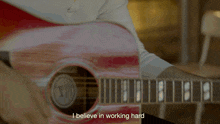 a close up of a person playing a guitar with the words " i believe in working hard "