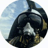 a man wearing a helmet and a gas mask looks out the window of an airplane