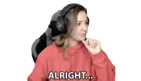 a woman wearing headphones is sitting in a chair and says alright