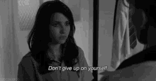 a black and white photo of a woman with the words " don t give up on yourself "